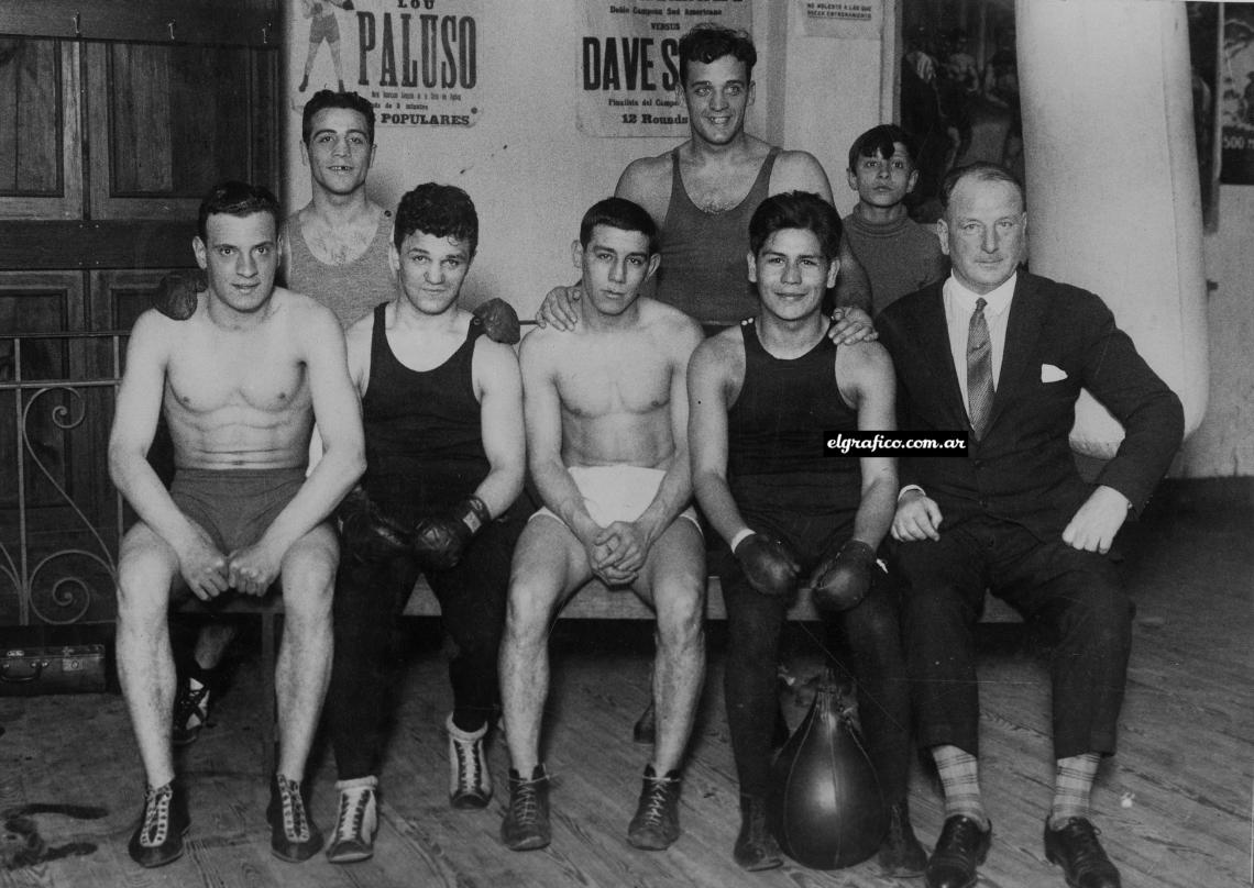 Paddy Mac Carthy, una de las más populares figuras de nuestro mundo pugilístico, vigila en el gimnasio del Lincoln el entrenamiento de algunos boxeadores profesionales, entre quienes están Stern, Barbará, Mallona y Víctor Peralta.