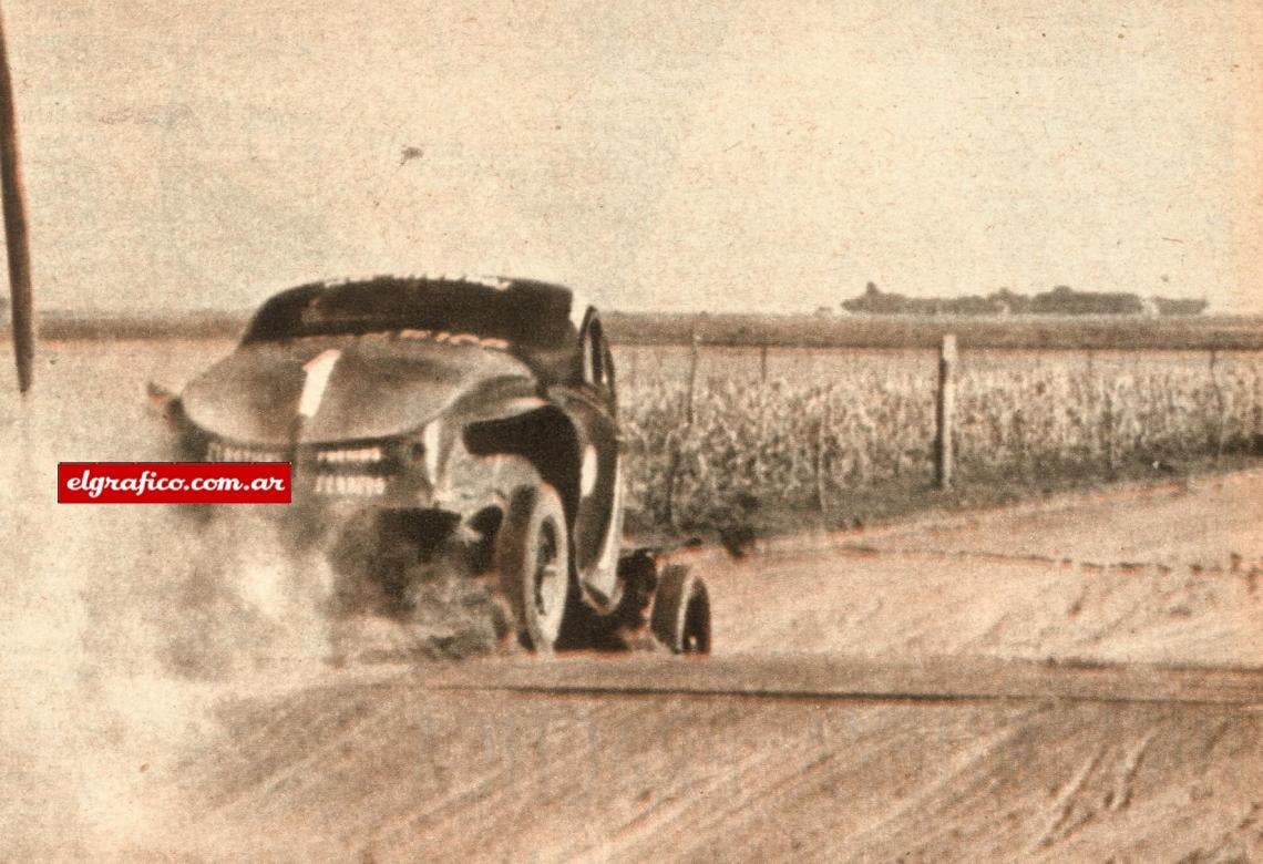 Aquí va el Ford de Juan Gálvez bajando un lomo de burro ya mermada su velocidad porque en el grupito que está adelante lo esperan para reabastecer la máquina de combustible. Para evitar un choque contra un señor que salió al camino Juan debió desertar cuando era puntero en la ruta y en la clasificación.