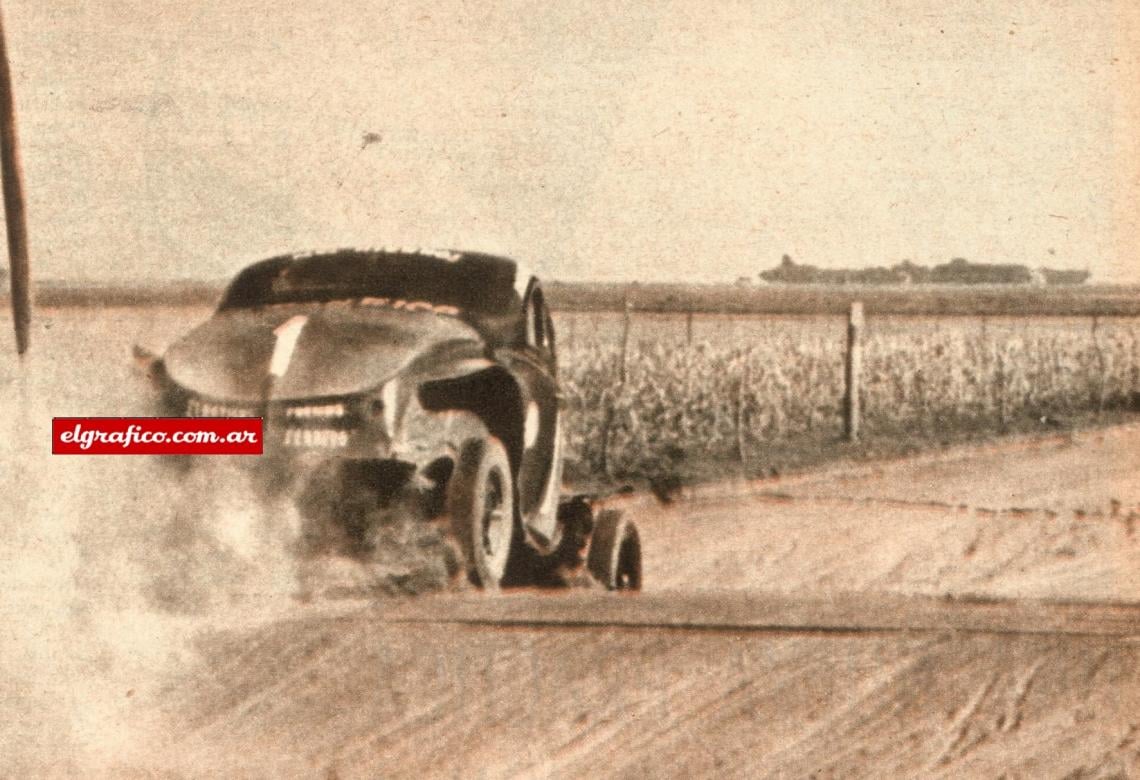 Imagen Aquí va el Ford de Juan Gálvez bajando un lomo de burro ya mermada su velocidad porque en el grupito que está adelante lo esperan para reabastecer la máquina de combustible. Para evitar un choque contra un señor que salió al camino Juan debió desertar cuando era puntero en la ruta y en la clasificación. 