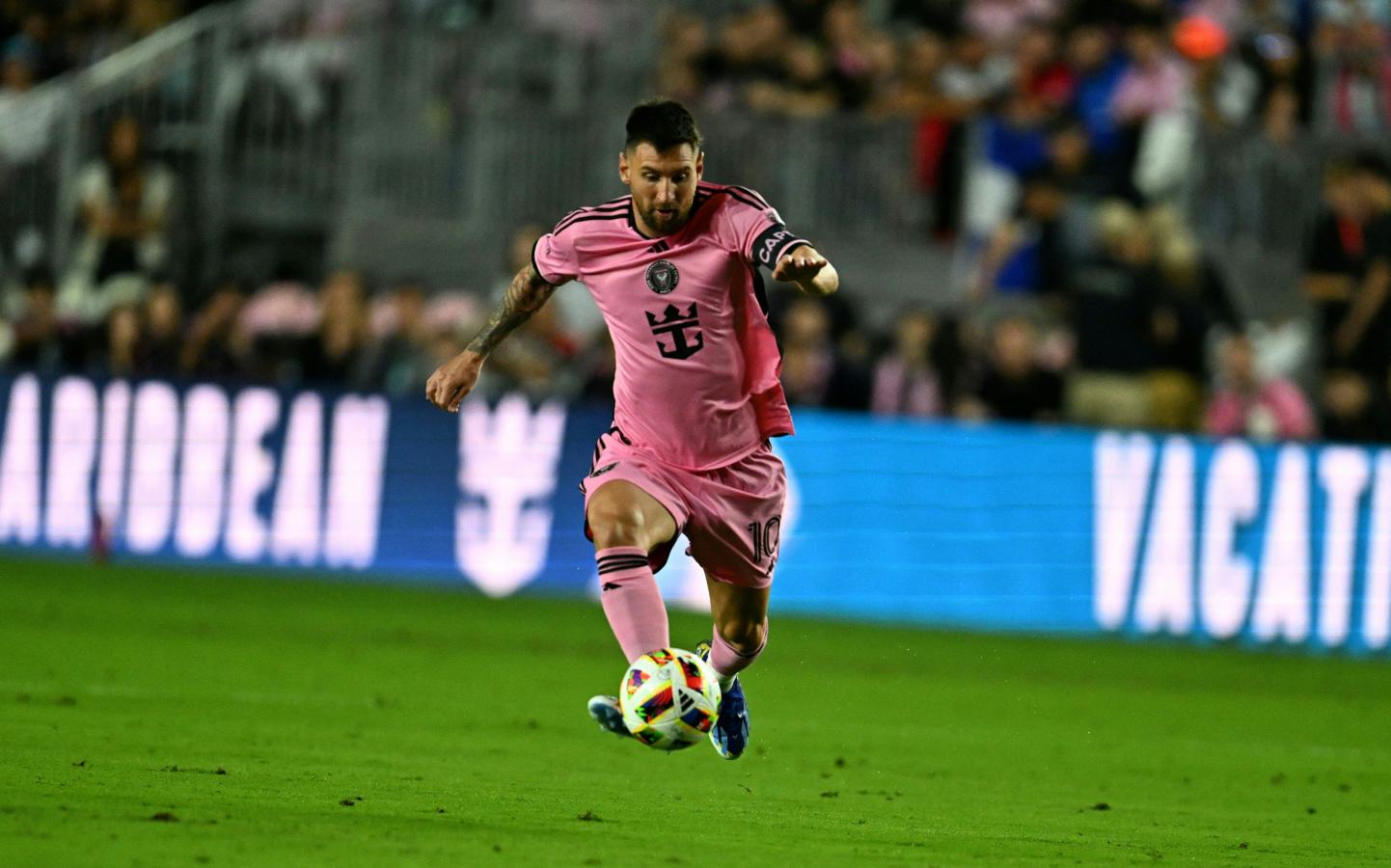 Imagen Messi lleva la pelota con su pierna derecha.