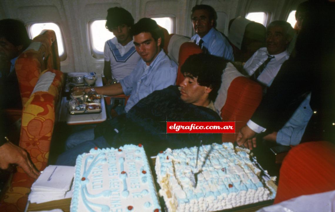 Imagen Cuando faltaba una hora para aterrizar la gente de Aerolíneas sorprendió con una torta para festejar el título. Diego dormía, no la probó. En la foto, Lalo Maradona. Muñoz y Macaya Márquez. 