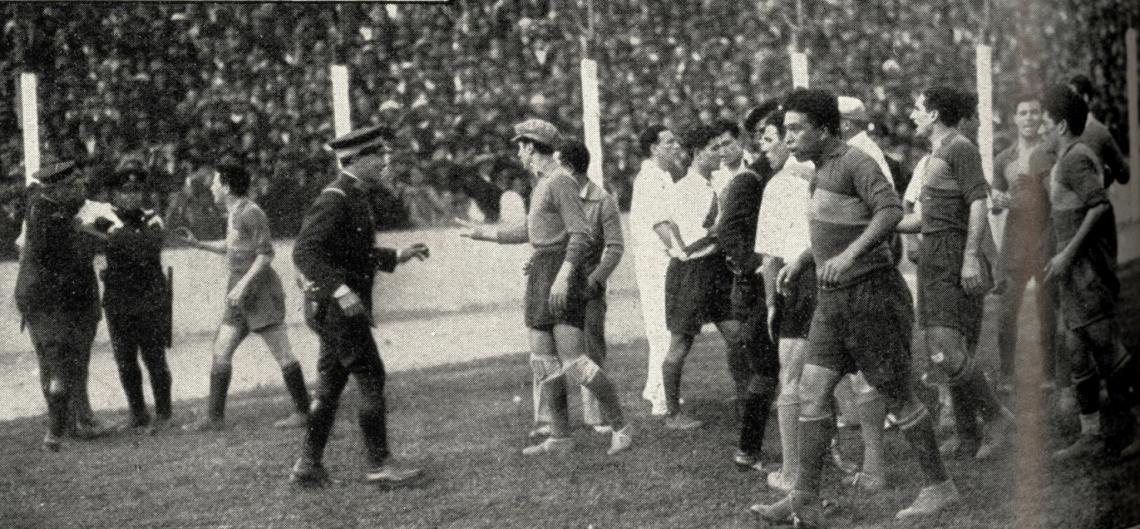 Imagen El match sufrió varias interrupciones por incidencias producidas entre los rivales. La que aquí reproducimos tuvo por protagonistas a Cuello, a quien sujetan dos agentes de policía, y Benavidez, que aparece en primer término, con gesto adusto. El lío se armó por un out-ball que cada uno de esos jugadores decía corresponderle tomar a su equipo.