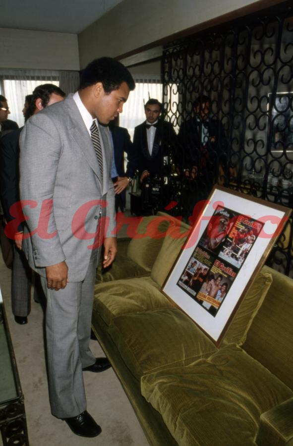 Muhammad Ali apreciando el cuadro con diferentes momentos de su carrera retratados en El Gráfico