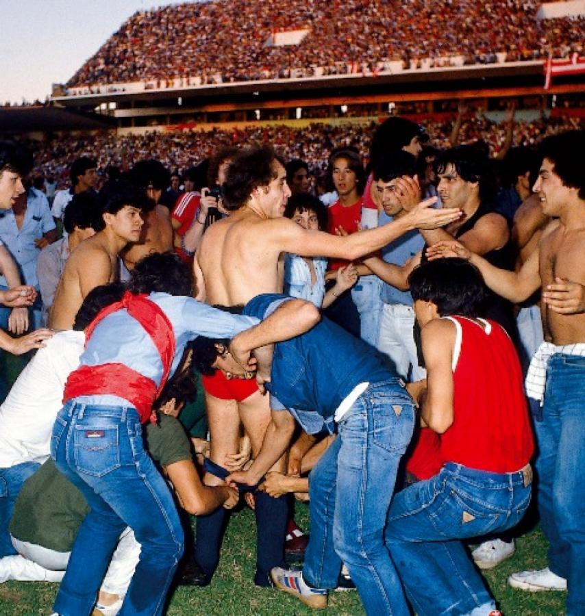 Imagen El partido frente a Racing se suspende por la invasión. Independiente es campeón Metropolitano 1983. Bochini es desvestido prolijamente por un grupo de hinchas, en una ceremonia de mal gusto que se hizo costumbre en nuestro fútbol.