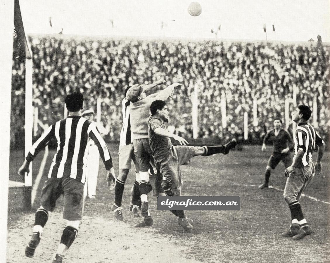 Imagen Un córner bien dirigido por Evaristo pone en peligro la valla de River Plate. Cherro se recuesta sobre el arquero, quien rechaza con los puflog apoyado por Balvidares, mientras Juan Carlos cuida el goal y Malazzo y Penella están a la expectativa. —