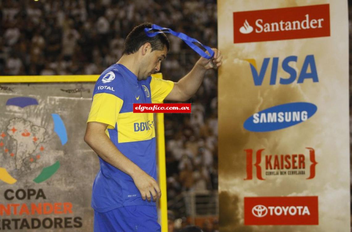 Imagen 2012. En el podio de premiación, se saca la medalla de subcampeón de la Copa Libertadores de América, tras la final perdida frente a Corinthians. Quebrado, Riquelme anunció tras el partido que se iba de Boca. "Estoy vacío y no tengo más nada para dar”. Volvería tras el regreso de Bianchi a la dirección técnica.