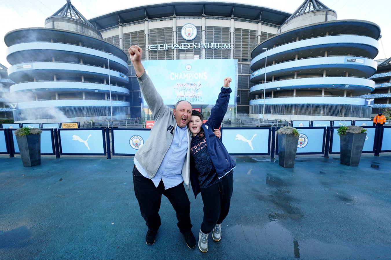 Imagen Dos hinchas del City celebran el título afuera del Etihad Stadium, que ya se vistió de campeón.