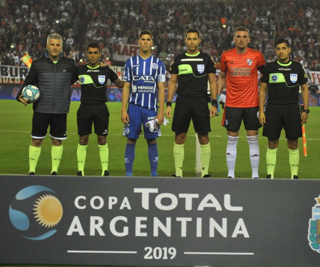 Los capitanes posan con los árbitros, el partido está por empezar.