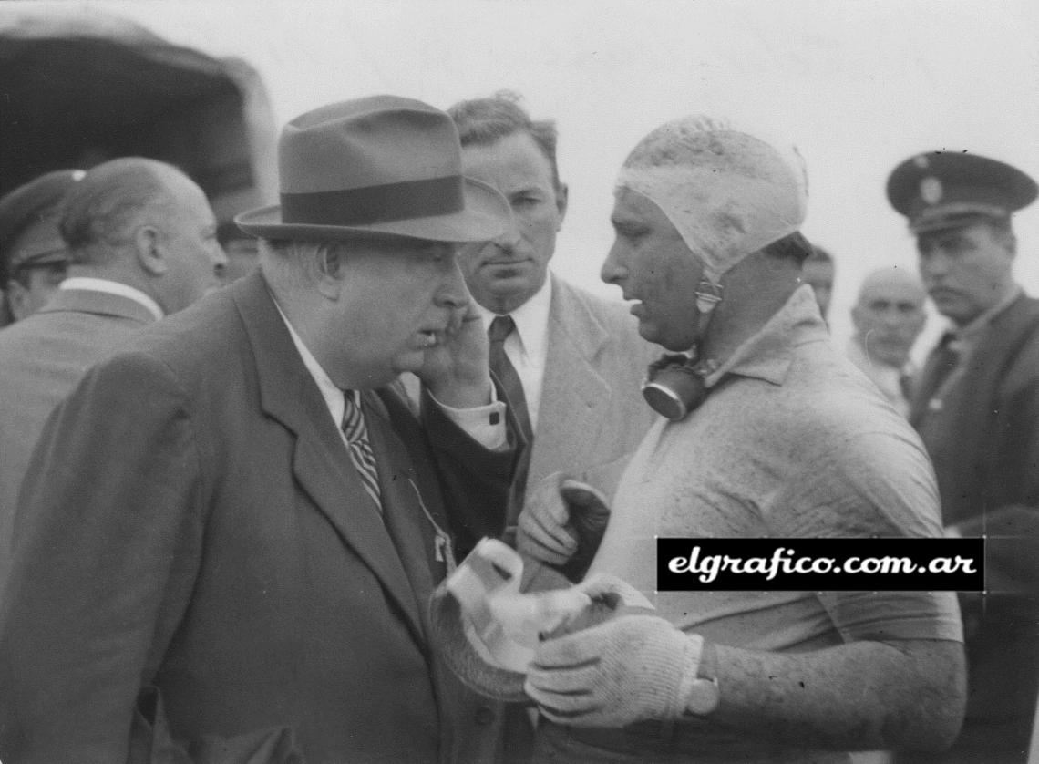 Imagen Juan Manuel Fangio siempre corría con casquete de género, como el que lleva en esta fotografía, que le fuera tomada cuando el mismo año del accidente probaba la B.R.M. Pero en carrera se hizo obligatorio el uso del casco, que Juan se reusaba a usar, y el casco le salvó a vida en Monza.El Doctor Terrico y Juan Manuel Fangio.