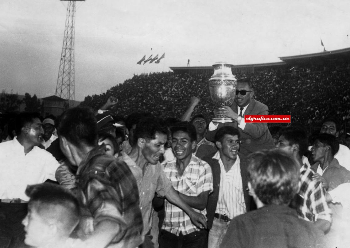 Imagen El clima, la voluntad y una orden de "morder" en todos lados, llevada a veces al extremo, le han permitido concretar esta actuación sin precedentes en un fútbol que carece de pergaminos. . Además, y por sobre todas las cosas, los bolivianos corren los noventa minutos con un tesón inigualable. Corren... y corren.El Presidente de la Federación Boliviana de Fútbol con la Copa en estadio de Cochabamba, luego de consagrarse campeón. Foto: Hugo Jordan.