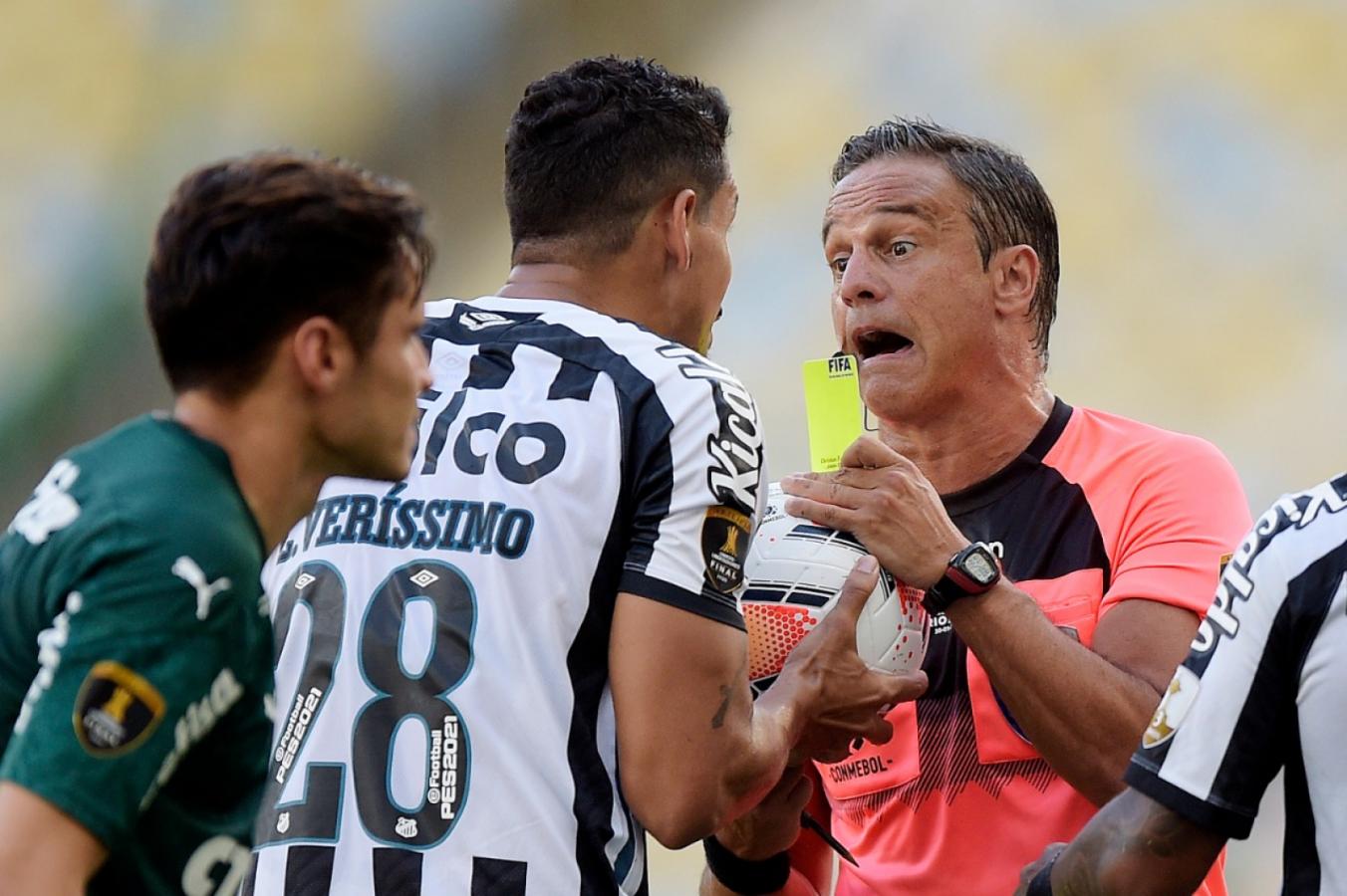 Imagen Patricio Loustau le muestra la tarjeta amarilla a Lucas Verissimo. El argentino amonestó a 8 futbolistas y echó a Cuca, DT de Santos. Foto: Staff Images / CONMEBOL