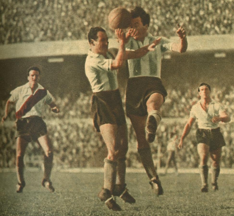 Dos defensores de Racing acuden al mismo tiempo para rechazar un tiro de Vernazza. Son ellos el zaguero García Pérez y. el hall Gutiérrez, quienes cumplieron con todo acierto la difícil tarea de vigilar una línea penetrante. La acción de los defensores alivió en parte la labor extrema de los arqueros.