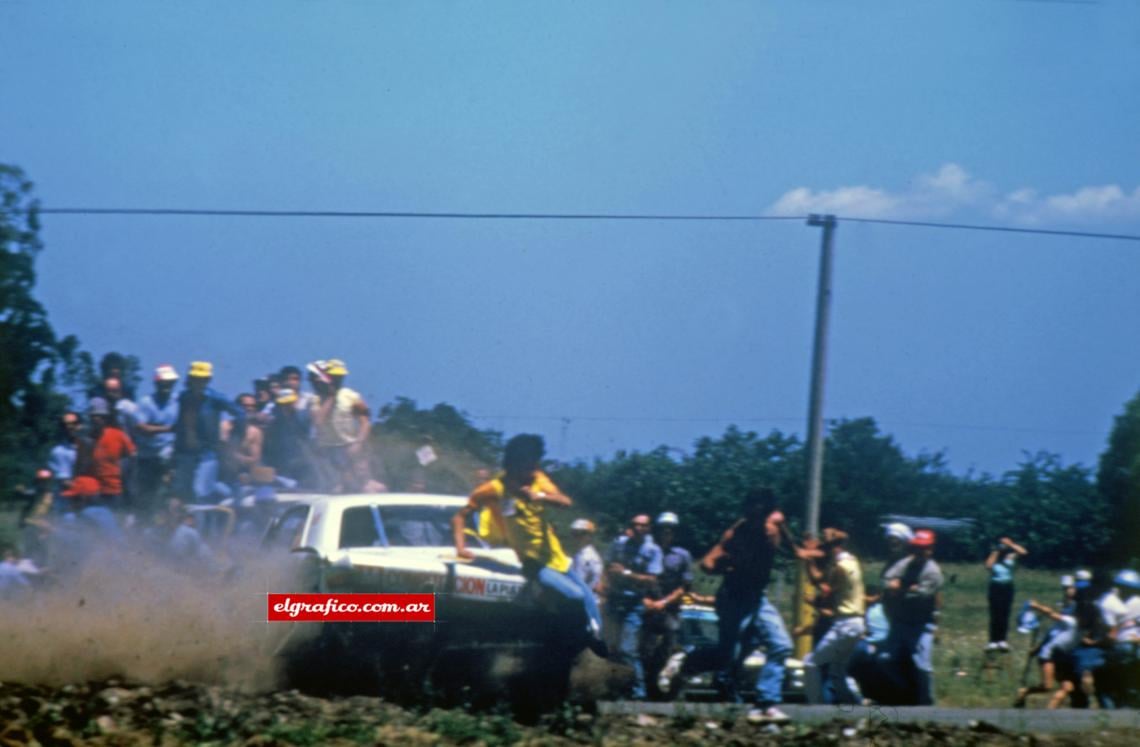 Imagen El Dodge N° 18 de Miguel Atauri barre de costado la “isla” previa a la rotonda de la ruta 36 cercana a La Plata. Era la segunda vuelta de la final de la carrera organizada por el Rotary Club Los Hornos y el Centro de Fomento de Capital Chica. Un banderillero es impactado por la cola del Dodge. Cunde el pánico entre espectadores mal ubicados.