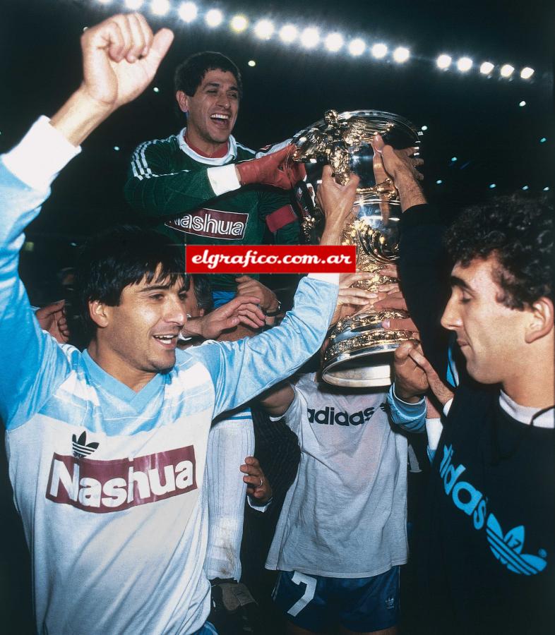 Imagen En Racing se convirtió casi en un ayudante más del Coco Basile: ordena, grita adentro de la cancha, aconseja, enseña. En la foto en andas con la Supercopa 1988 su último título como jugador y el primero que ganaba “La Academia” desde la Intercontinental 1967. “No vine a Racing con el ataúd colgando como pensaron algunos, a mi nunca me van a agarrar mansito o entregado. Seguro”.