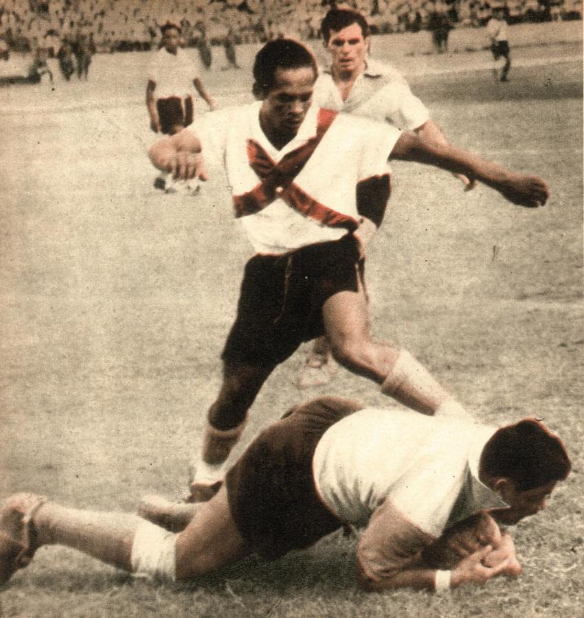 Se arroja al suelo el guardavalla de Banfield, Graneros, con lo que consigue apoderarse de la pelota y quitar peligro a la atropellada de Lazón, delantero peruano. Atrás de este último se ve al zaguero Bagnato, que jugó muy bien durante la gira.