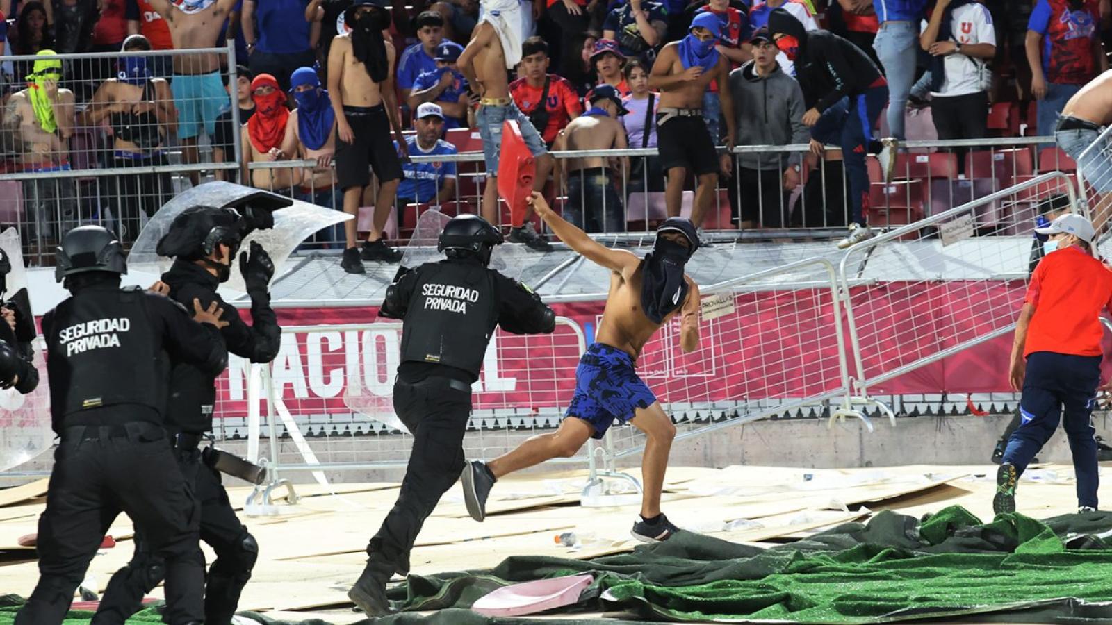 Imagen Un barra de la U se escapa de la policía con una butaca en la mano tras lanzarse sobre la pista atlética.