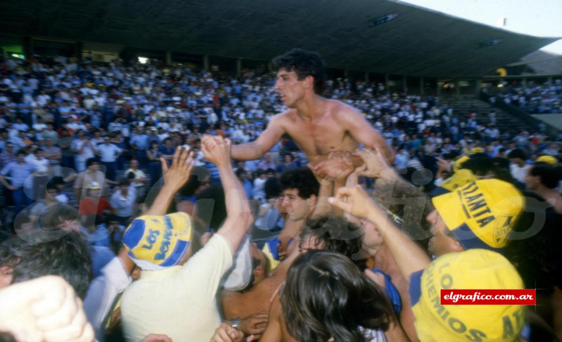 Alfredo Manuel Torres en andas de la hinchada. El reconocimiento a uno de los hombres fundamentales de la campaña y a la figura frente a Central Córdoba. Como fondo, la platea local asociándose con aplausos al festejo bohemio.