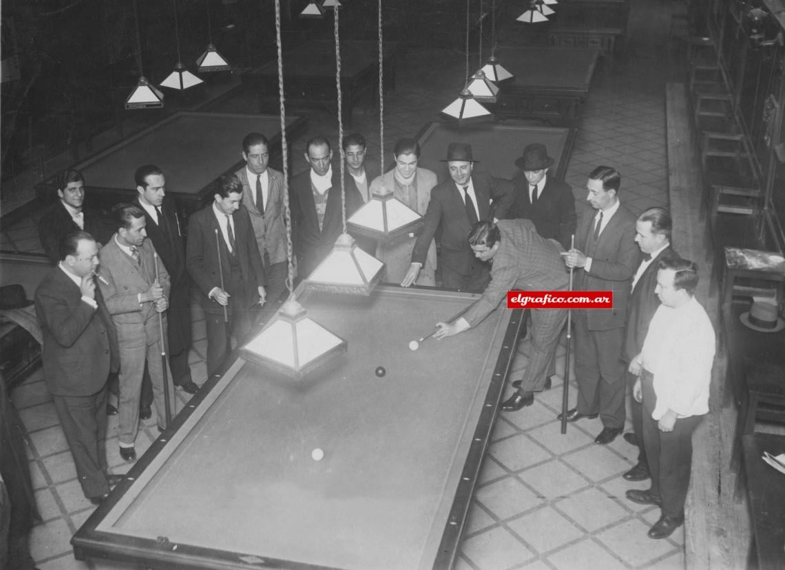 Imagen EL “negro" es un crack en las tres bandas. La barra de "Los 20 Billares" se ha reunido para seguir las incidencias del match, "El que ha sido forward -dice Seoane — debe saber jugar un poquito al billar. Es como encontrarse dentro del área: éste, que es Rava, busca la manera de hacerme entrar en juego; pero primero la pelota irá allá, a la derecha, donde está Zoilo; después, la tocará Lalin, con un pase a Orsi, y Mumo va a hacer que yo la reciba solito, enfrente del arco..." Y conste que la bola le obedece, puesto que es roja.