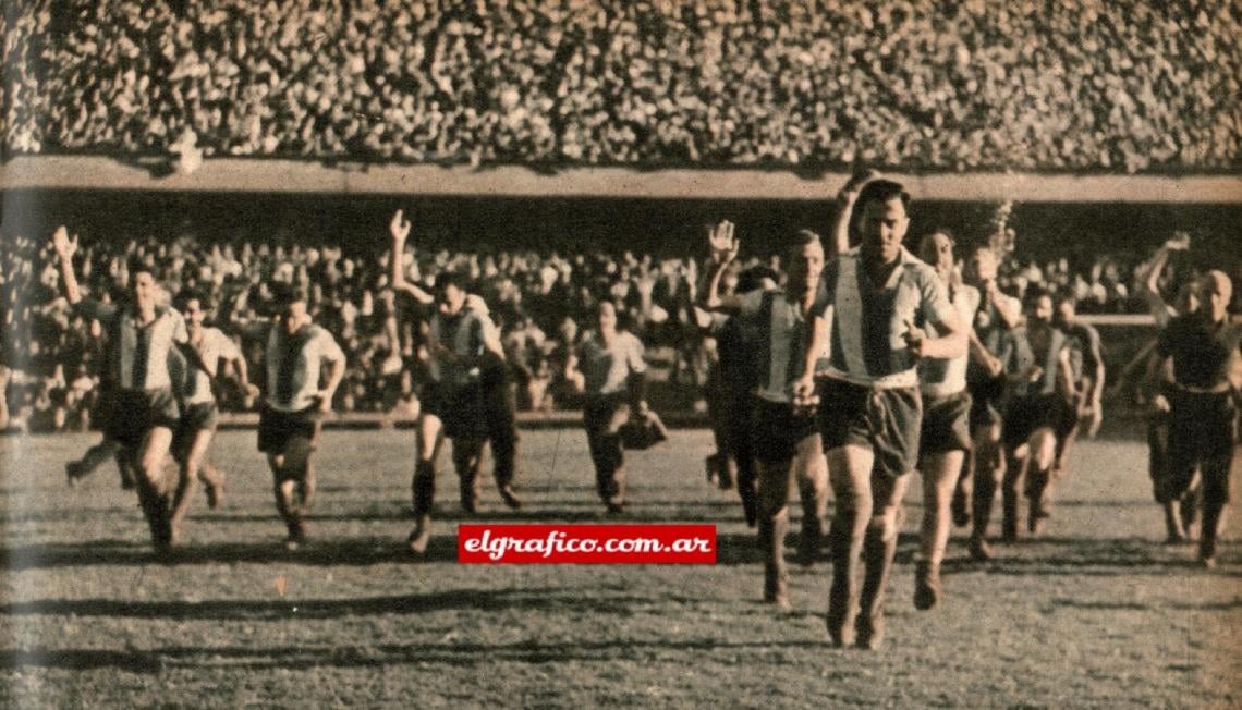 Imagen La vuelta de honor. Terminado definitivamente el encuentro Racing - Boca, en el estadio de Brandsen y Del Crucero — que fué la cancha utilizada por Racing durante el año, — los flamantes campeones reciben la ovación del público.