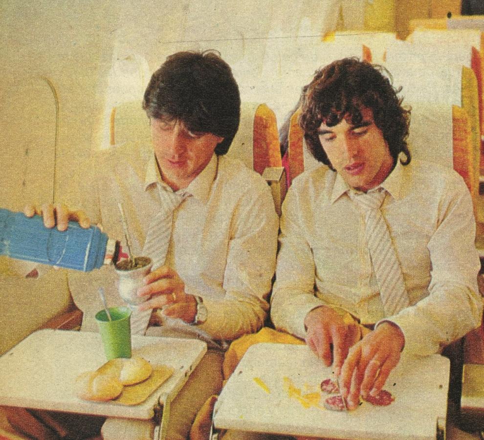 Imagen Pedro Damián Monzón y su mate sobre el DC-10 de Varig en pleno vuelo a Tokio. Alejandro Esteban Barberón lo ayuda y prepara algunos salamines para acompañar. Fue el primer lugar donde se reunió el grupo para pasar el tiempo.