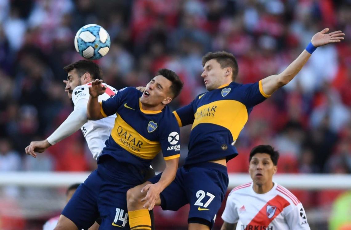 Imagen Capaldo y Soldano de Boca buscan ganarle de arriba a Pratto. De fondo, los mira expectante Enzo Pérez.