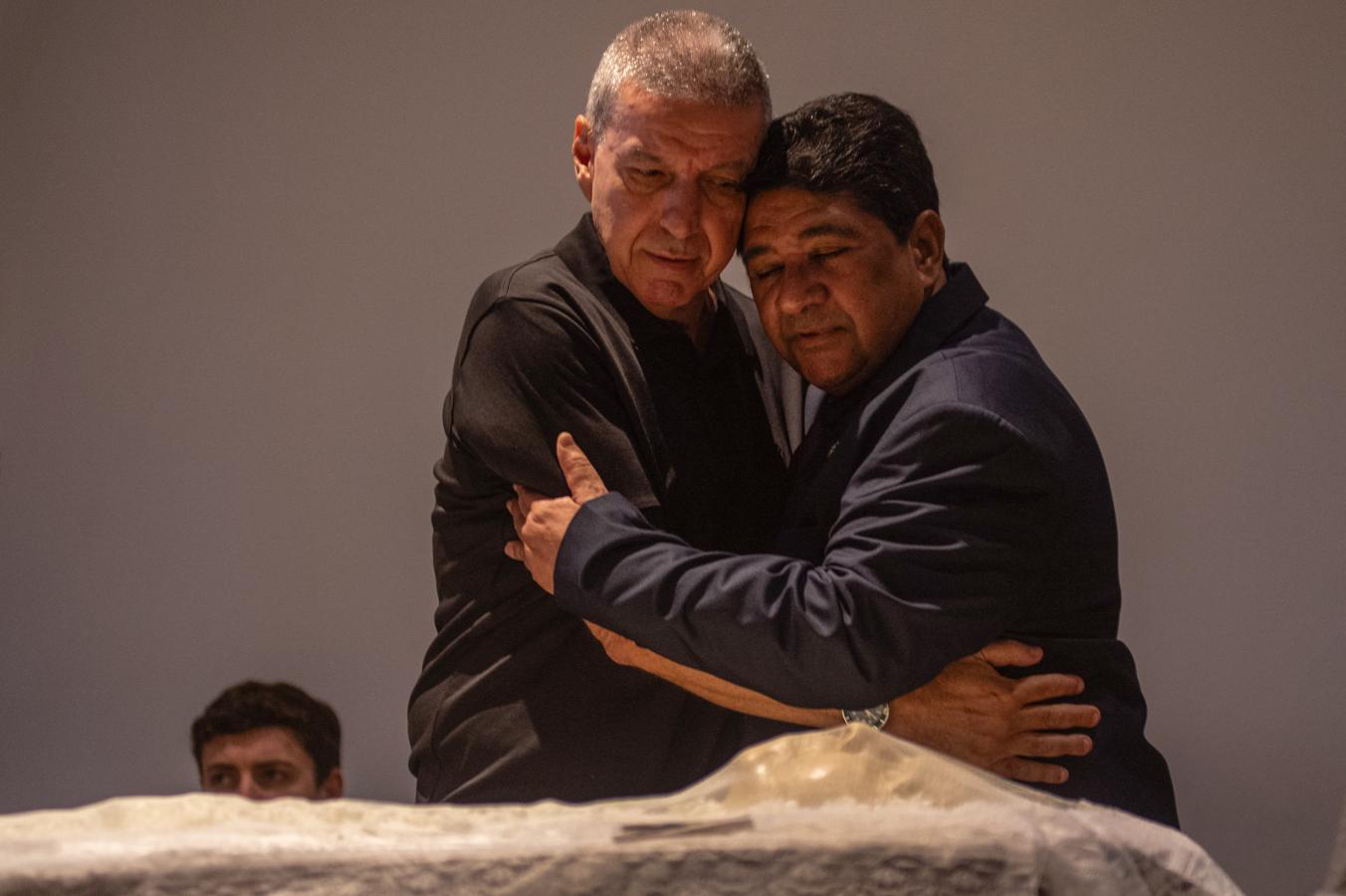 Imagen El abrazo de Ednaldo Rodrigues, presidente de la CBF con el hijo de Zagallo, frente a los restos de la leyenda.